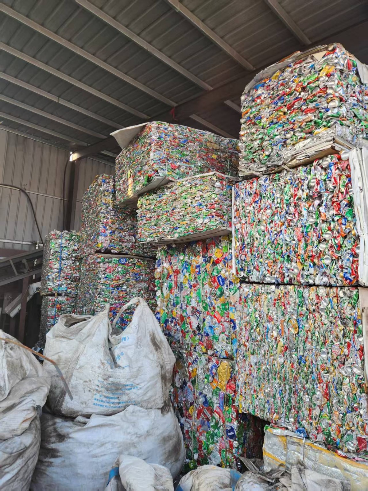 Compressed used beverage can scrap bales stored in a warehouse